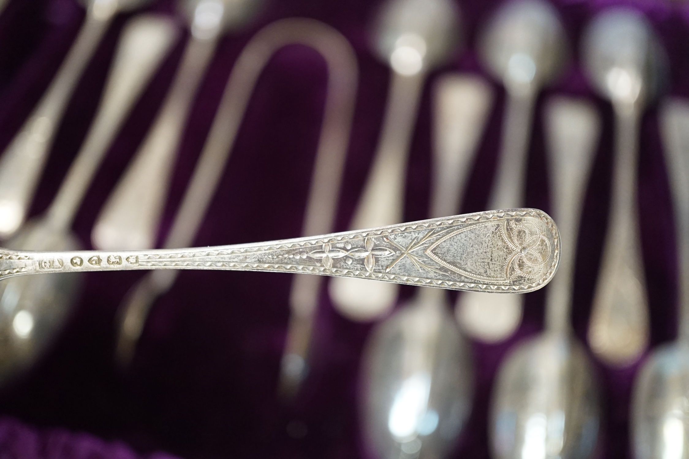 A cased set of twelve Victorian engraved silver rat tail pattern teaspoons with sugar tongs, George Adams, London, 1882.